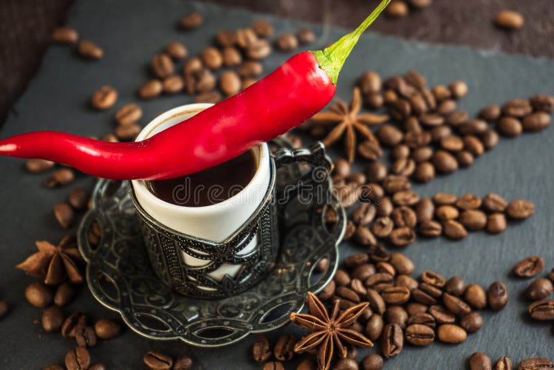 Traditional turkish coffee in vintage cup, anise, roasted beans with hot spicy chili pepper on brown background. Traditional turkish coffee in vintage cup, anise, roasted beans with hot spicy chili pepper on brown background