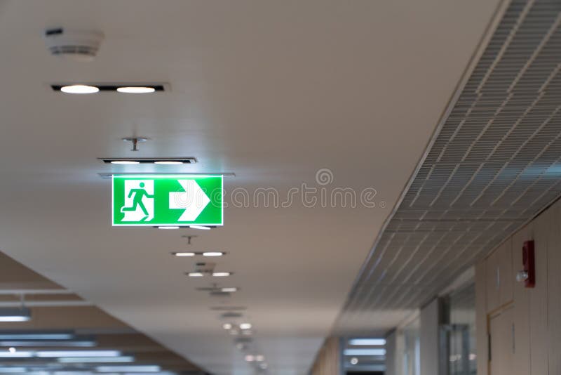 Cair verde do sinal do escape de fogo no teto no escritório imagens de stock royalty free Cair verde do sinal do escape de fogo no teto no escritório imagens de stock royalty free
