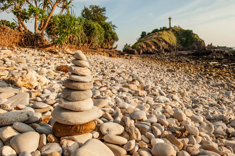 Cairn zen meditation, stones balance on stone beach, mountain light house blurred backgrounds. Lanta Island, Thailand