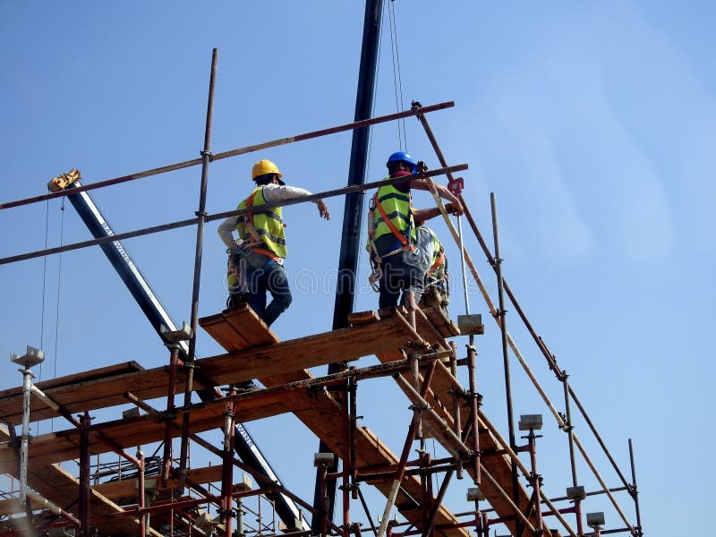 Cairo, Egypt, May 10 2023 Engineers and Workers at a Construction Site with Scaffolds and