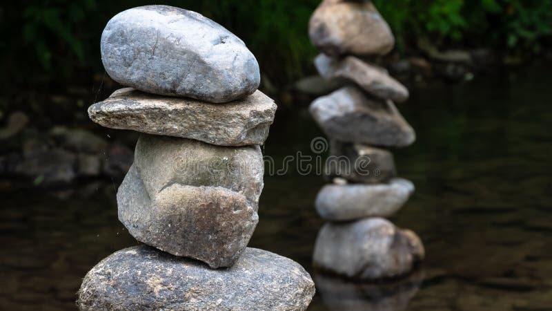 Cairos de pedra crua parados orgulhosamente na água do riacho