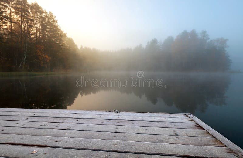 Cais congelado no lago na manhã nevoenta do frio ainda fotos de stock Cais congelado no lago na manhã nevoenta do frio ainda fotos de stock