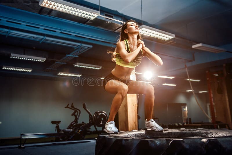 Caixa apta da jovem mulher que salta em um estilo do crossfit fotos de stock Caixa apta da jovem mulher que salta em um estilo do crossfit fotos de stock