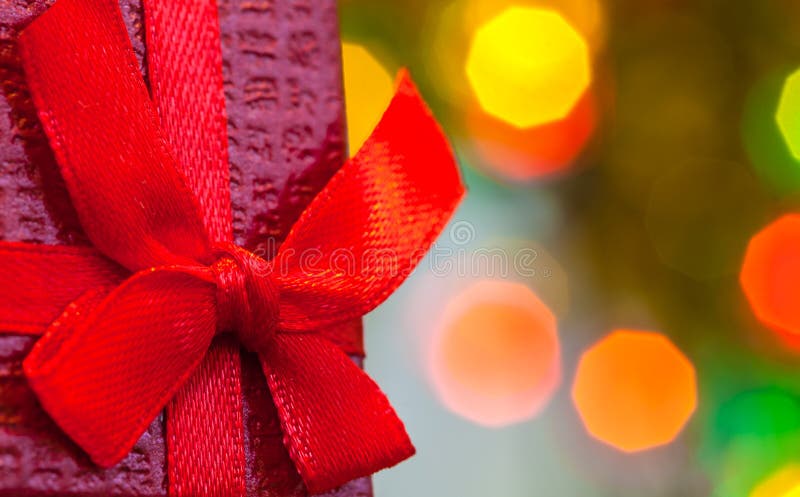 Caixa com o presente do Natal com fundo vermelho do feriado do sumário da luz da curva e do bokeh do Natal fotografia de stock royalty free Caixa com o presente do Natal com fundo vermelho do feriado do sumário da luz da curva e do bokeh do Natal fotografia de stock royalty free
