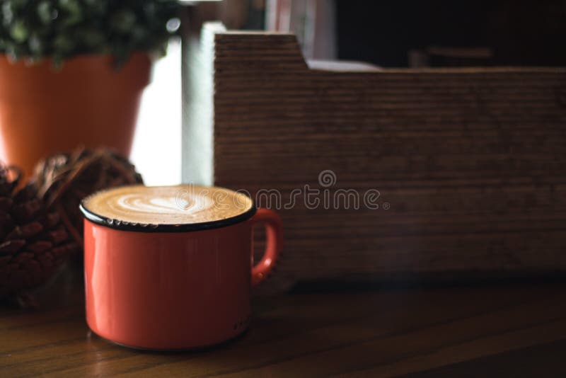 Caixa de madeira e latte em uma caneca vermelha imagem de stock Caixa de madeira e latte em uma caneca vermelha imagem de stock