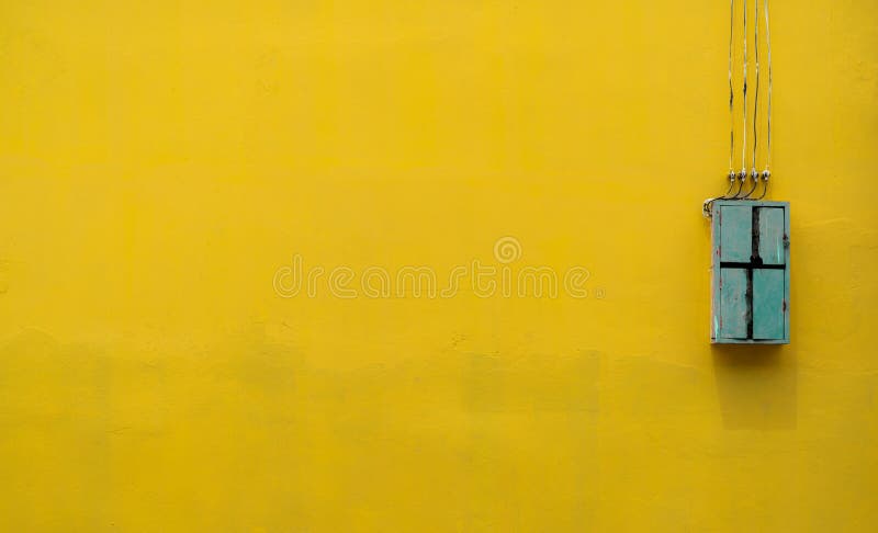 Caixa de madeira verde, equipamento do controle bonde na fábrica no fundo amarelo do muro de cimento do vintage com espaço da cóp foto de stock Caixa de madeira verde, equipamento do controle bonde na fábrica no fundo amarelo do muro de cimento do vintage com espaço da cóp foto de stock