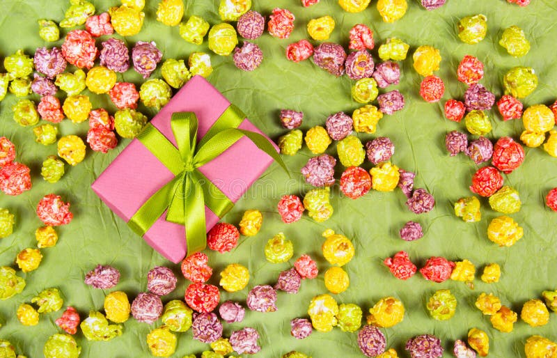Caixa de presente cor-de-rosa com uma curva e um caramelo verdes submissos imagem de stock royalty free Caixa de presente cor-de-rosa com uma curva e um caramelo verdes submissos imagem de stock royalty free