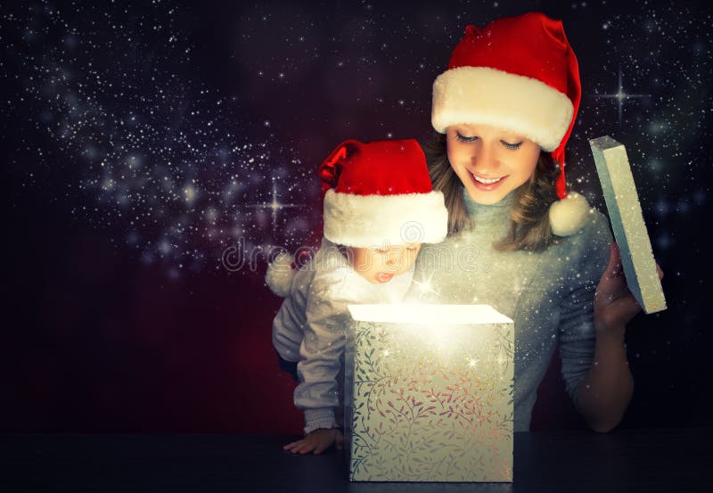 Caixa de presente mágica do Natal e uma mãe e um bebê felizes da família foto de stock royalty free Caixa de presente mágica do Natal e uma mãe e um bebê felizes da família foto de stock royalty free