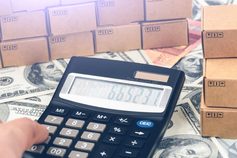 Calculator, lorry, airplane, cardboard boxes on a money background. Cargo Delivery Business Development Concept. Calculator, lorry, airplane, cardboard boxes on a money background. Cargo Delivery Business Development Concept.