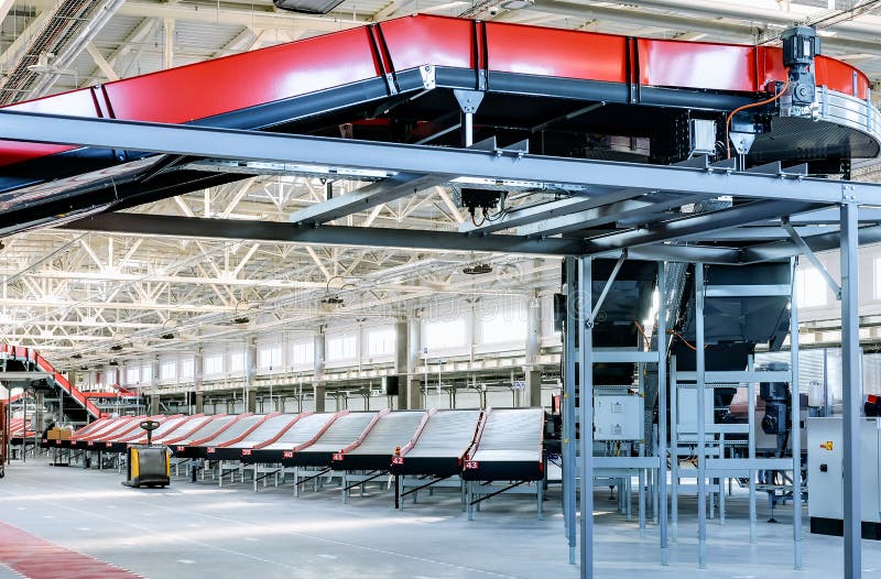 Empty conveyor sorting belt at distribution warehouse. Distribution hub for sorting packages and parcels delivered by air transportation. Empty conveyor sorting belt at distribution warehouse. Distribution hub for sorting packages and parcels delivered by air transportation.