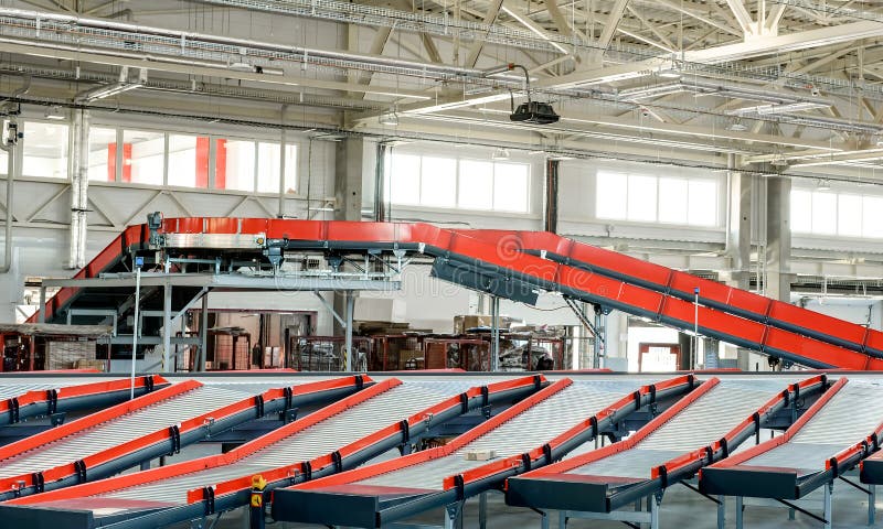 Empty conveyor sorting belt at distribution warehouse. Distribution hub for sorting packages and parcels delivered by air transportation. Empty conveyor sorting belt at distribution warehouse. Distribution hub for sorting packages and parcels delivered by air transportation.