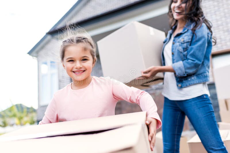 caixas levando da mãe e da filha para mover-se em imagens de stock caixas levando da mãe e da filha para mover-se em imagens de stock