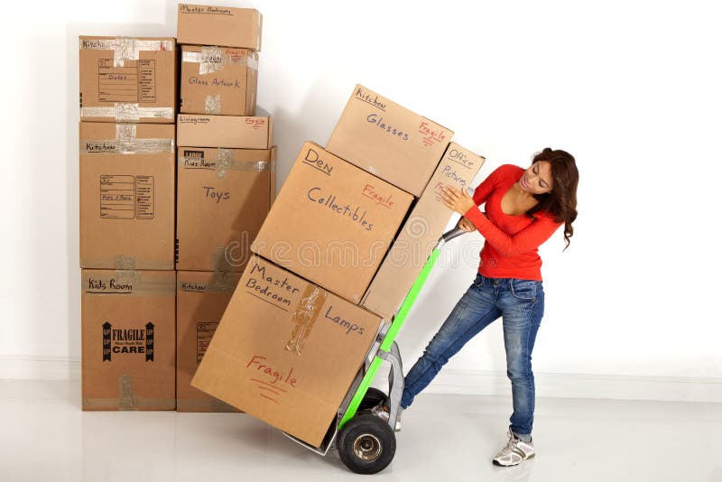 Caixas moventes da jovem mulher com com um caminhão ou uma zorra de mão