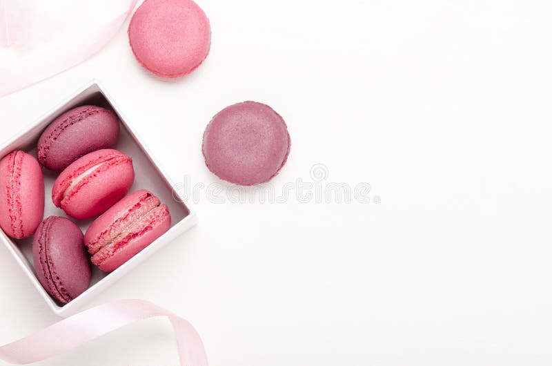 Caja con los macarrones coloridos en un fondo blanco con las cintas Invitaci?n dulce, pasteles, comida alta en calor?as Copie el fotografía de archivo libre de regalías Caja con los macarrones coloridos en un fondo blanco con las cintas Invitaci?n dulce, pasteles, comida alta en calor?as Copie el fotografía de archivo libre de regalías