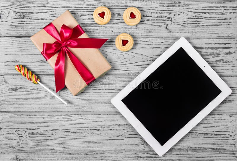 Caja de regalo con el arco, las galletas del corazón y la tableta rojos Concepto romántico St Día del ` s de la tarjeta del día d fotografía de archivo libre de regalías Caja de regalo con el arco, las galletas del corazón y la tableta rojos Concepto romántico St Día del ` s de la tarjeta del día d fotografía de archivo libre de regalías