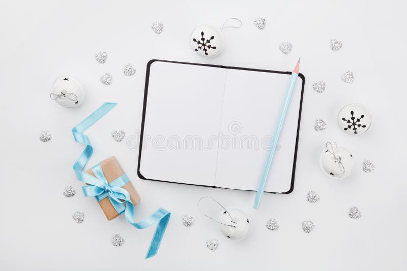 Caja de regalo de la Navidad con la cinta azul, el cuaderno vacío y el cascabel en el escritorio blanco arriba Tarjeta de felicit imagenes de archivo Caja de regalo de la Navidad con la cinta azul, el cuaderno vacío y el cascabel en el escritorio blanco arriba Tarjeta de felicit imagenes de archivo