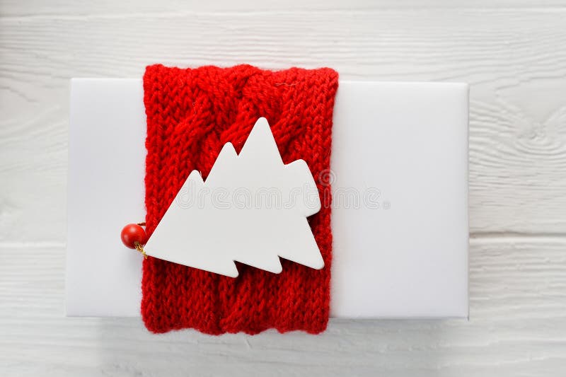 Caja de regalo de la Navidad blanca con la etiqueta hecha punto roja de la cinta y de la maqueta en la forma de árbol de abeto en imágenes de archivo libres de regalías Caja de regalo de la Navidad blanca con la etiqueta hecha punto roja de la cinta y de la maqueta en la forma de árbol de abeto en imágenes de archivo libres de regalías