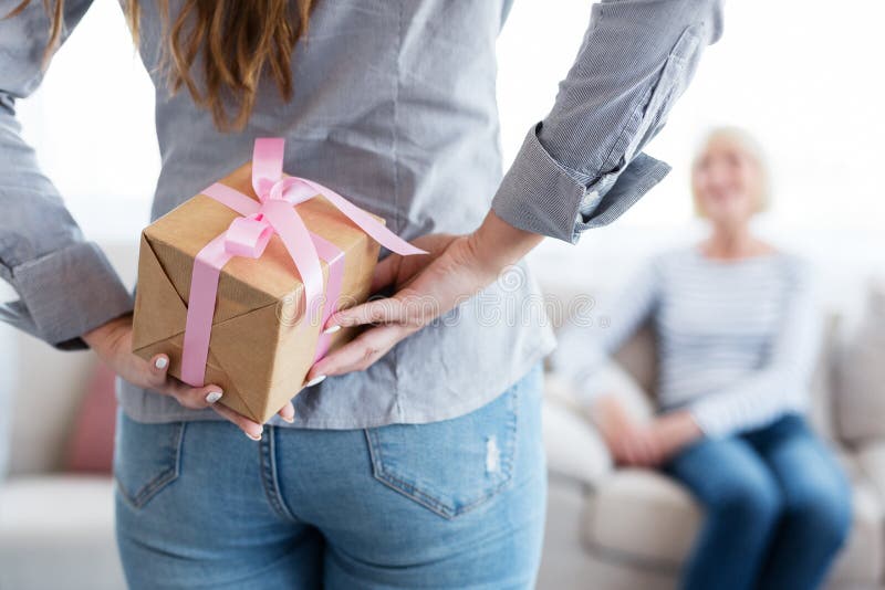 Caja de regalo de la tenencia de la mujer detrás de la parte posterior para su madre imagen de archivo libre de regalías Caja de regalo de la tenencia de la mujer detrás de la parte posterior para su madre imagen de archivo libre de regalías