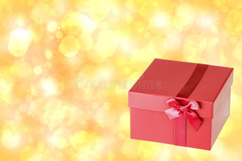 Caja de regalo roja de la Navidad en fondo abstracto de oro del bokeh de la falta de definición fotografía de archivo Caja de regalo roja de la Navidad en fondo abstracto de oro del bokeh de la falta de definición fotografía de archivo