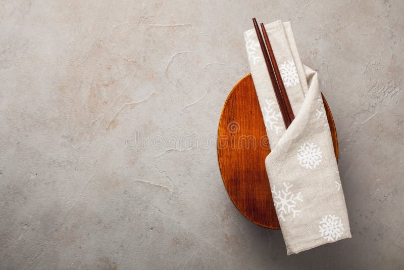 Caja del almuerzo japonesa de madera cerrada con los palillos, envueltos en un paño festivo en una tabla de piedra vieja Visión s imagenes de archivo Caja del almuerzo japonesa de madera cerrada con los palillos, envueltos en un paño festivo en una tabla de piedra vieja Visión s imagenes de archivo