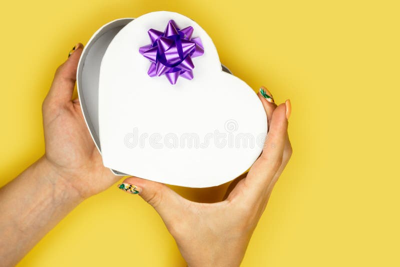 Caja en forma de corazón abierta de la mujer en fondo amarillo Concepto del amor del d?a de tarjetas del d?a de San Valent?n foto de archivo Caja en forma de corazón abierta de la mujer en fondo amarillo Concepto del amor del d?a de tarjetas del d?a de San Valent?n foto de archivo