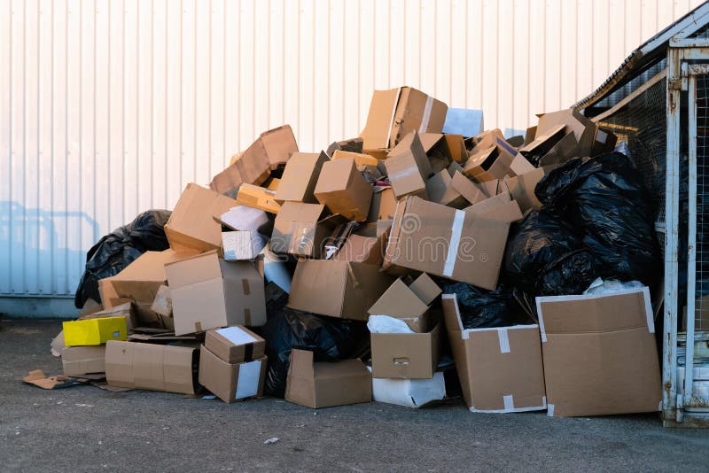 Cajas de papel junto a un cubo de basura Pila de residuos de papel al aire libre en la ciudad Reciclaje de papel, nadie
