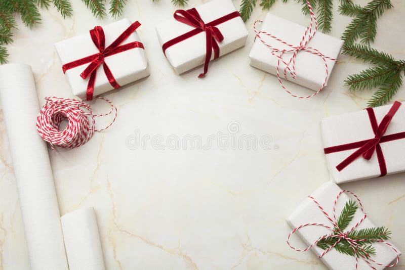 Cajas de regalo de la Navidad envueltas en el documento blanco del arte y la cinta roja decorativa sobre superficie marmórea Ende imagenes de archivo Cajas de regalo de la Navidad envueltas en el documento blanco del arte y la cinta roja decorativa sobre superficie marmórea Ende imagenes de archivo