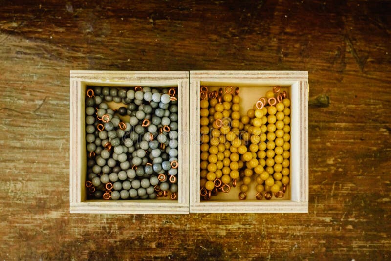 Cajones con cuentas para aprender a contar en un aula montessori en madera envejecida fotos de archivo