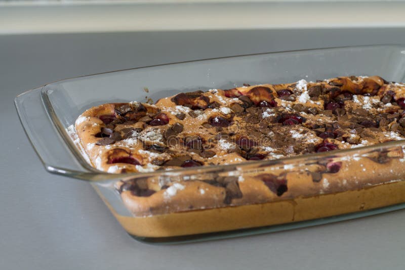 Cake with cherry and chocolate on gray kitchen table. Cake with cherry, chocolate and powdered sugar in glass brazier on gray kitchen table stock photo Cake with cherry and chocolate on gray kitchen table. Cake with cherry, chocolate and powdered sugar in glass brazier on gray kitchen table stock photo