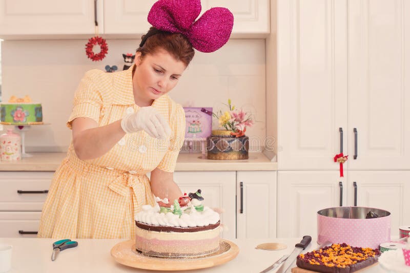 Cake decorating in the kitchen of a woman passionate about baking. Pastry chef decorating a cake. Woman in bakery decorating a cake with pasion. Cake decorating in the kitchen of a woman passionate about baking. Pastry chef decorating a cake. Woman in bakery decorating a cake with pasion.