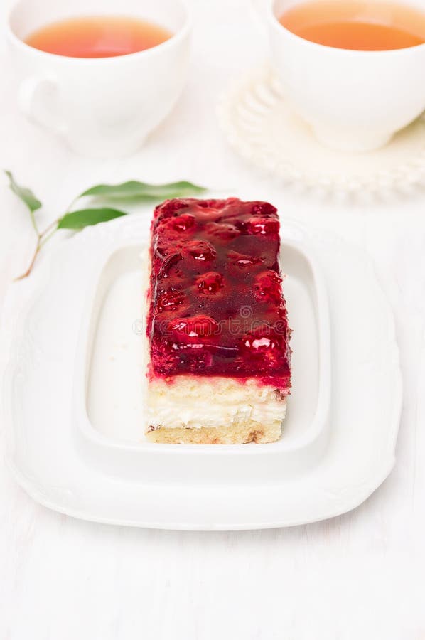 Cake with strawberry jelly and two cups of tea