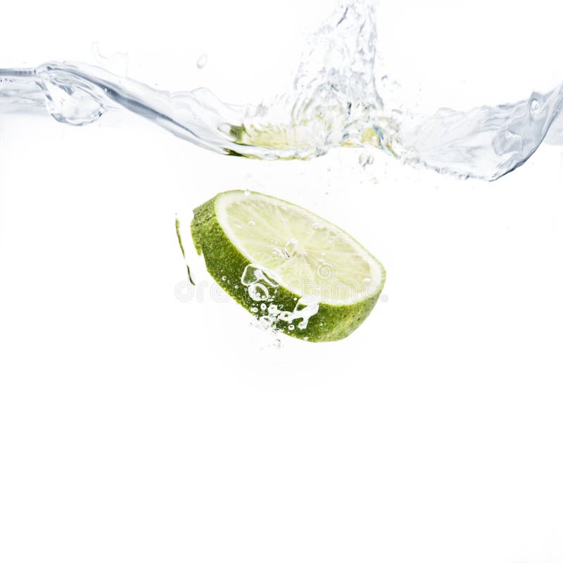 Lime slice splashing into water with white background. Lime slice splashing into water with white background