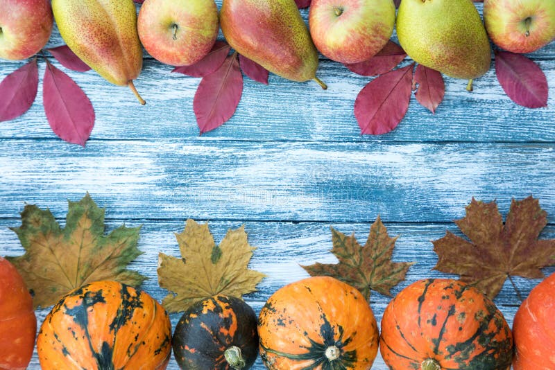 Calabazas, manzanas, peras y hojas de otoño en fondo de madera fotos de archivo Calabazas, manzanas, peras y hojas de otoño en fondo de madera fotos de archivo