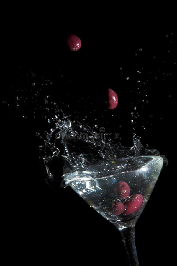 Calamata olives dropping into glass