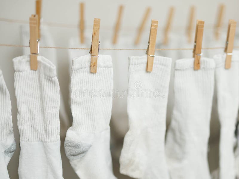White socks clipped to rope to air dry indoors to save money on energy costs. White socks clipped to rope to air dry indoors to save money on energy costs