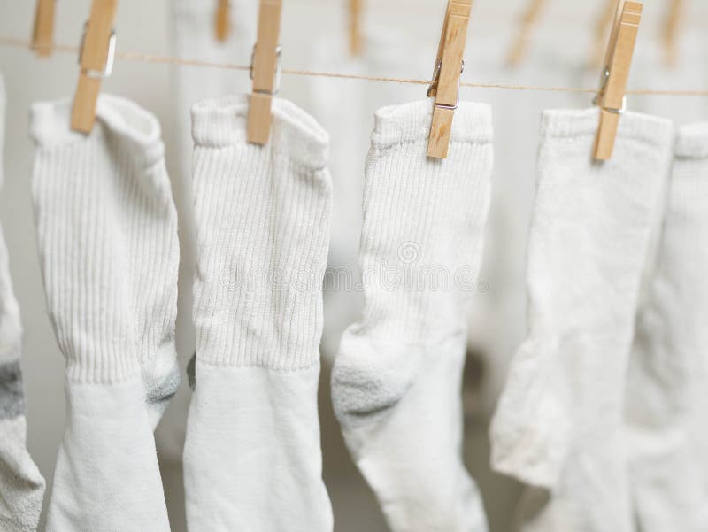 White socks clipped to rope to air dry indoors to save money on energy costs. White socks clipped to rope to air dry indoors to save money on energy costs