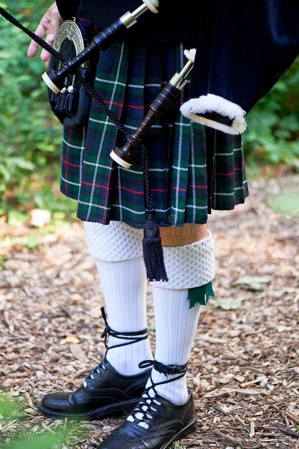 Calcetines Blancos Un Con Una Gaita, Una Falda Escocesa En Una Jaula Con Una Raya Y Roja Cultura Los Detalles De La Foto de archivo - Imagen de verde, juego: