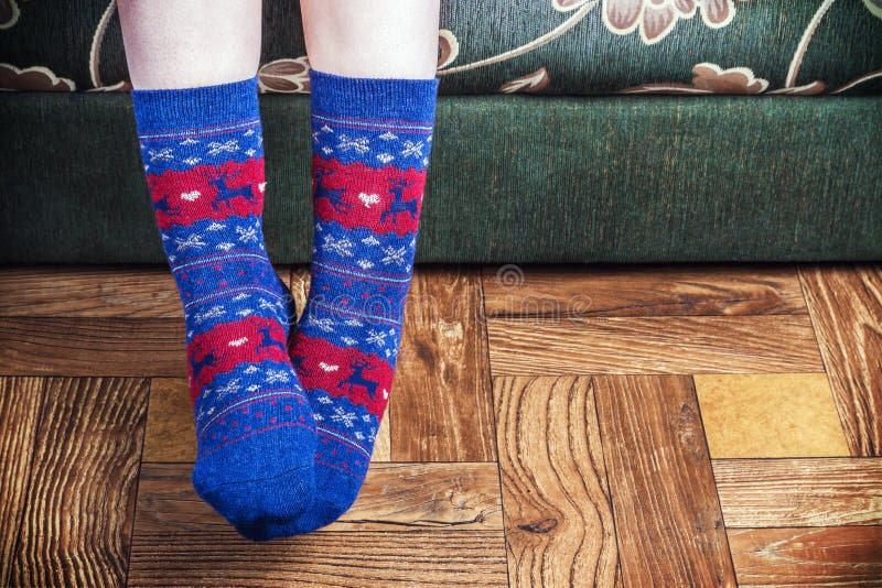 Christmas socks in blue on feet on the wooden floor. Christmas socks in blue on feet on the wooden floor