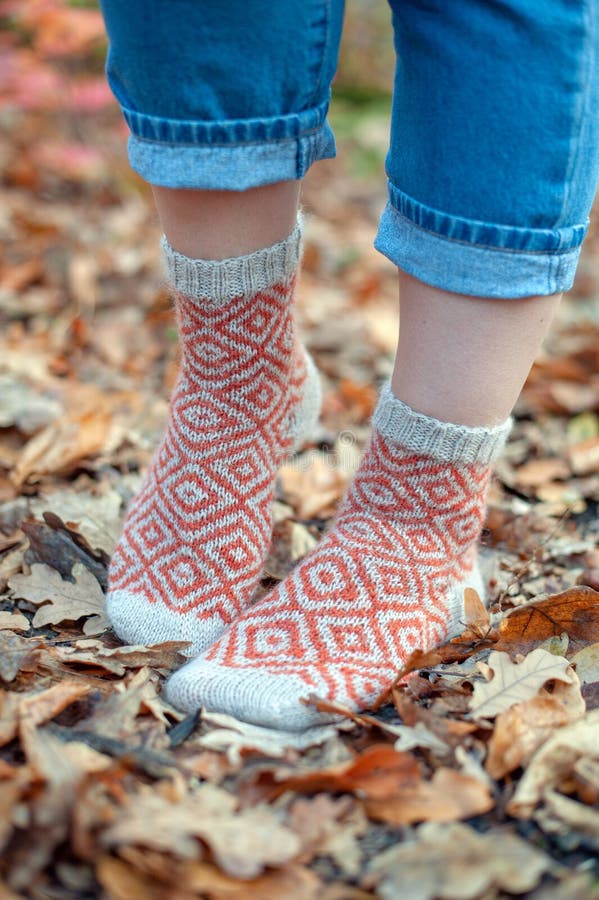 Handmade knitted socks on the background of leaves. Handmade knitted socks on the background of leaves