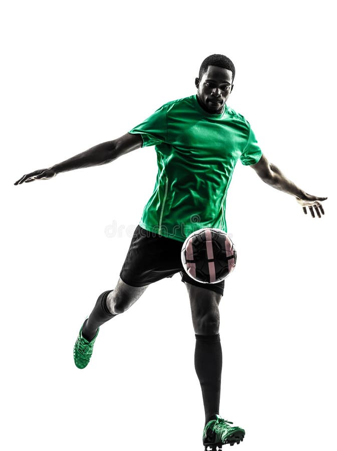 Calciatore africano dell'uomo che dà dei calci alla siluetta fotografia stock libera da diritti Calciatore africano dell'uomo che dà dei calci alla siluetta fotografia stock libera da diritti