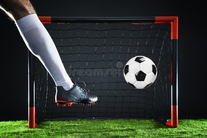 Calcio Concetto di campionato con il calciatore Fucilazione del percussore sullo scopo immagine stock Calcio Concetto di campionato con il calciatore Fucilazione del percussore sullo scopo immagine stock