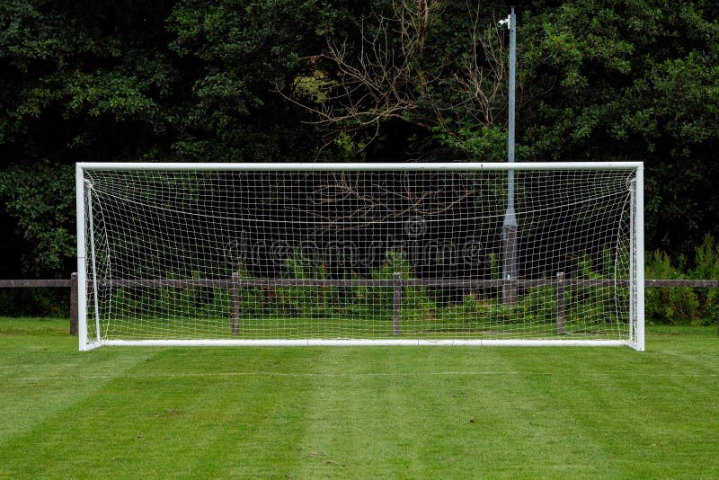 Side of football of soccer goal post with net in focus. Field out of focus. Sport background and equipment. Front view. Side of football of soccer goal post with net in focus. Field out of focus. Sport background and equipment. Front view.