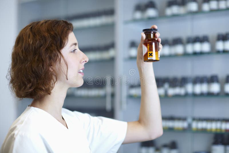 Pharmacist taking a look at Calciumchlorid in pharmacy. Pharmacist taking a look at Calciumchlorid in pharmacy