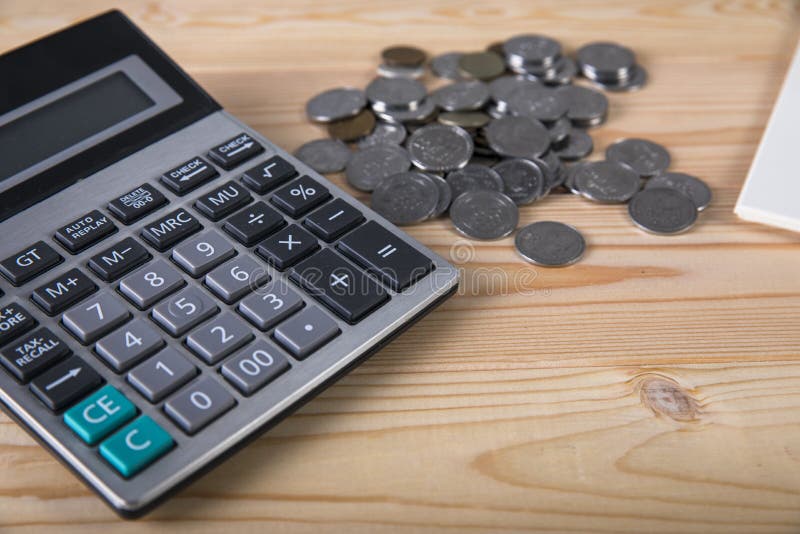 Calculator, coins, notepad and pen stock photography