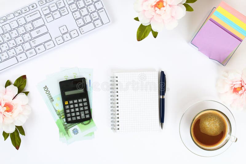Calculator, euro banknotes, blank notebook on a white desktop next to a coffee mug and a keyboard. Top view, flat layout. Copy the stock images Calculator, euro banknotes, blank notebook on a white desktop next to a coffee mug and a keyboard. Top view, flat layout. Copy the stock images