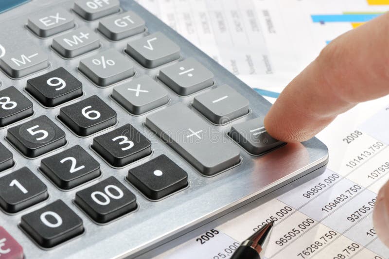 The calculator and a hand of the man stock photo