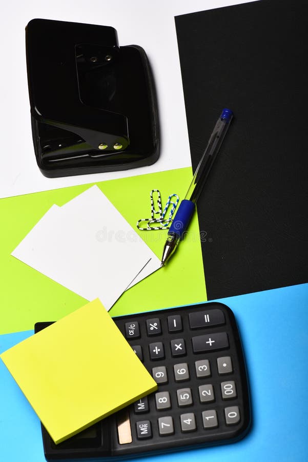 Calculator, hole punch, business cards, note paper, paper clips, pen royalty free stock photo