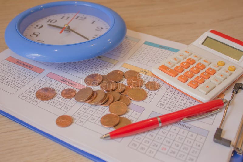 Calculator with Pen and Money on Calendar. Coin Stack with a Clock Background Stock Photo