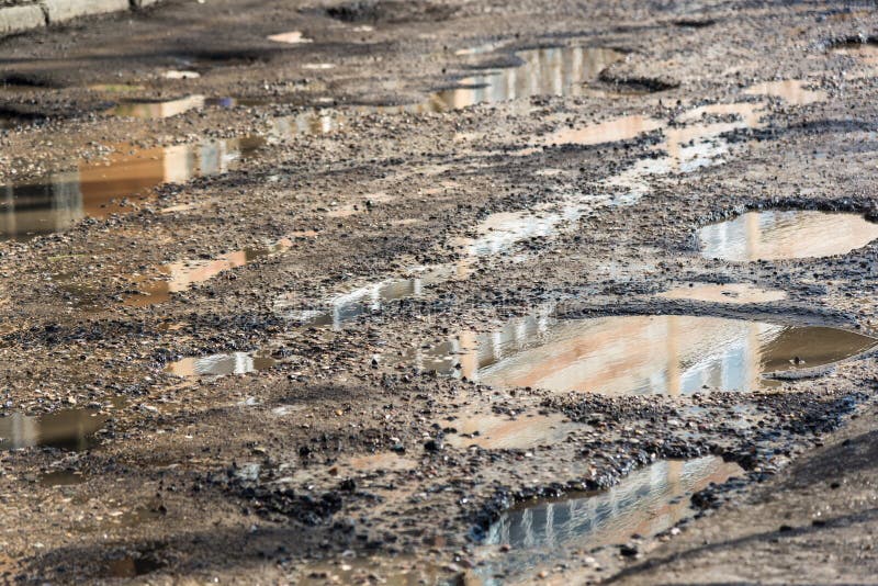 Caldeirões na estrada asfaltada enchida com água fotos de stock Caldeirões na estrada asfaltada enchida com água fotos de stock