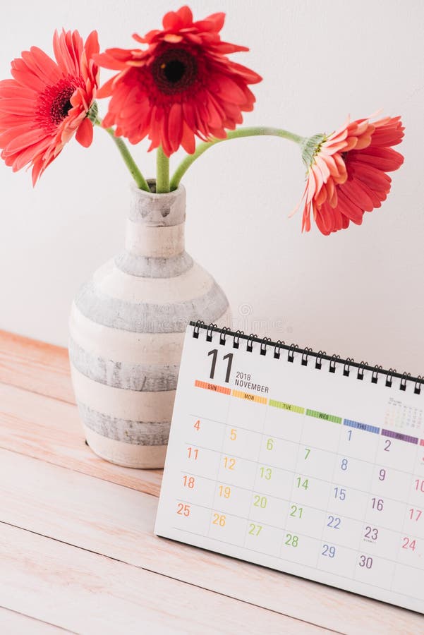Calendar And Vase With Flower On Table Against Color Background, Space